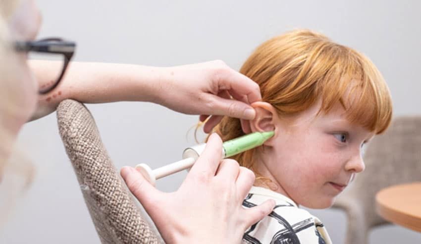 A Hearing Aid Mould Being Placed in a Young Girl's Ear to Make a Custom Ear Plug