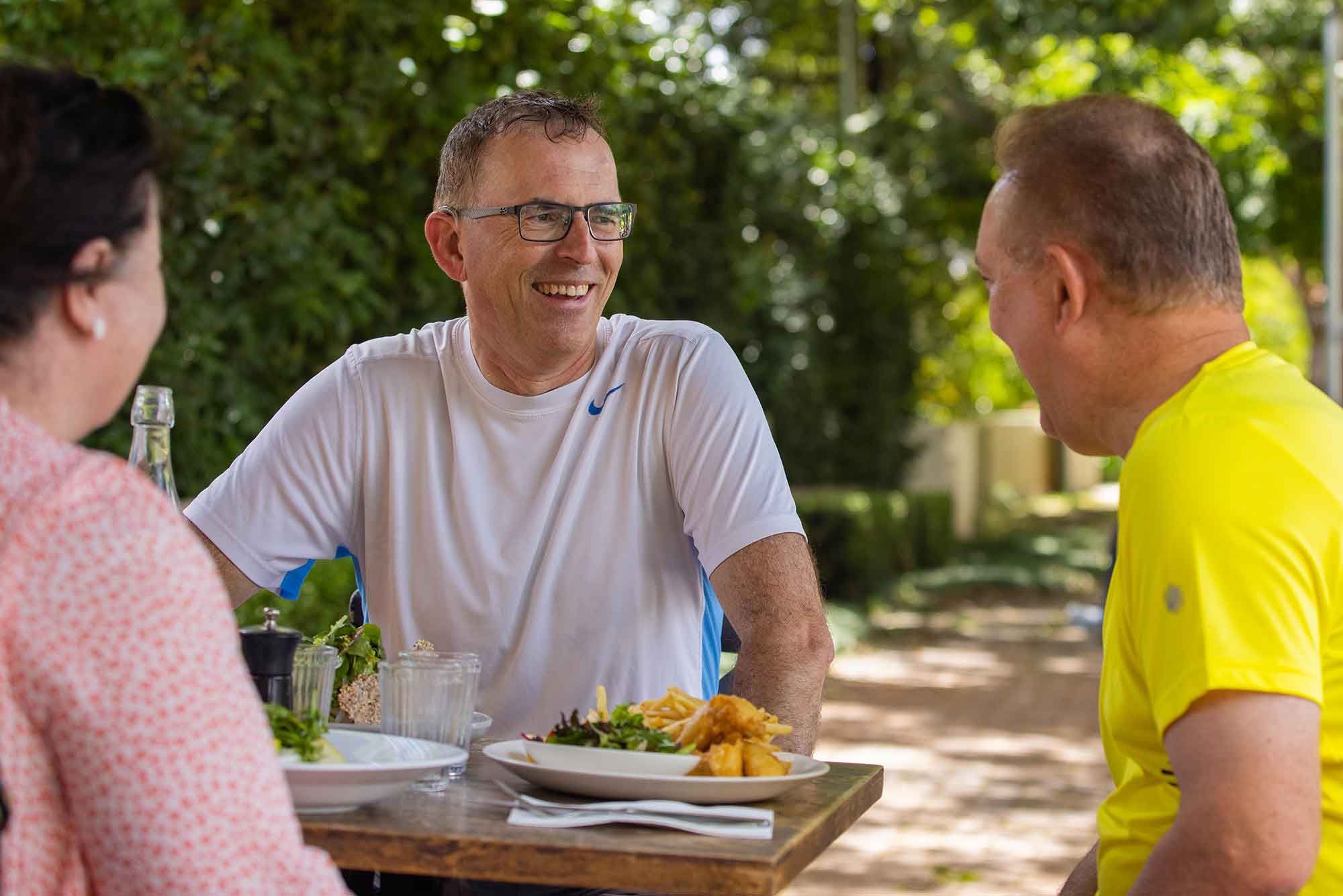 A Man Chatting and Enjoying Lunch with His Friends