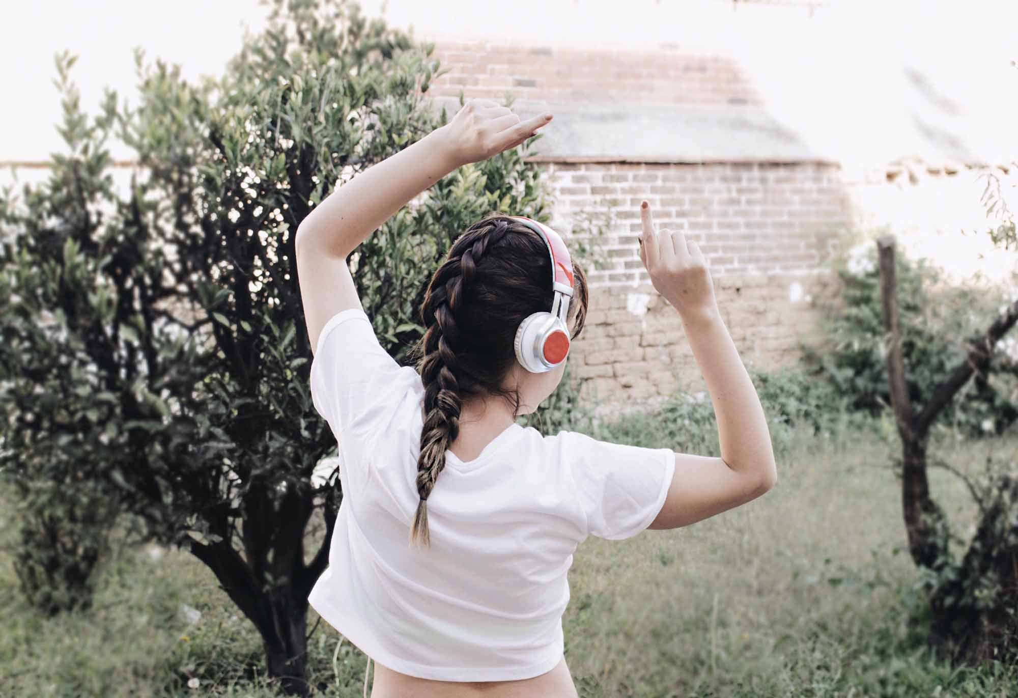 A Girl Dances Outside While Wearing Headphones