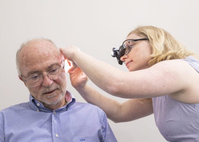 An Elderly Man Having His Ears Examined for Wax Management