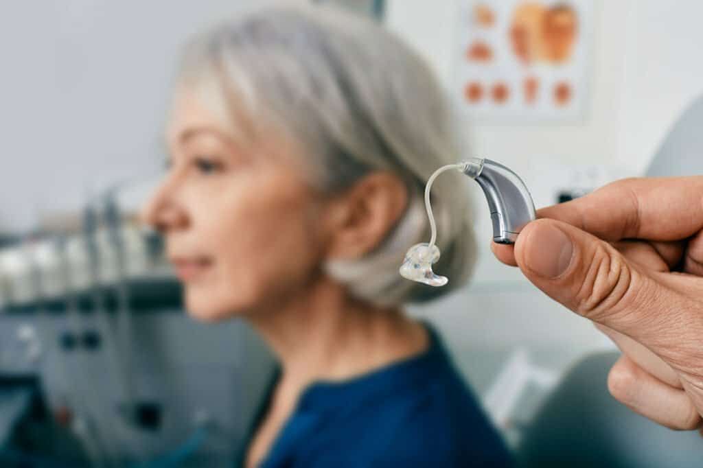 Man Holding Hearing Aids