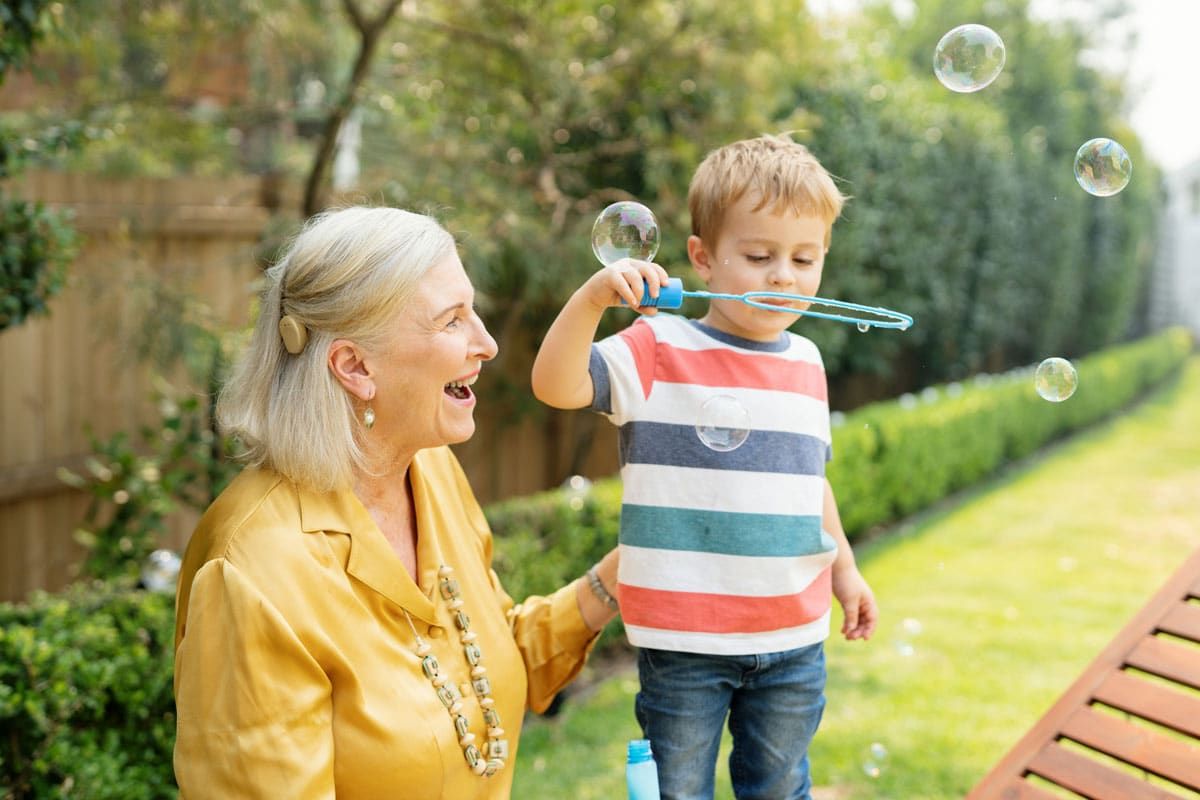A Grandmother and Her Grandson Playing Outside with Bubbles