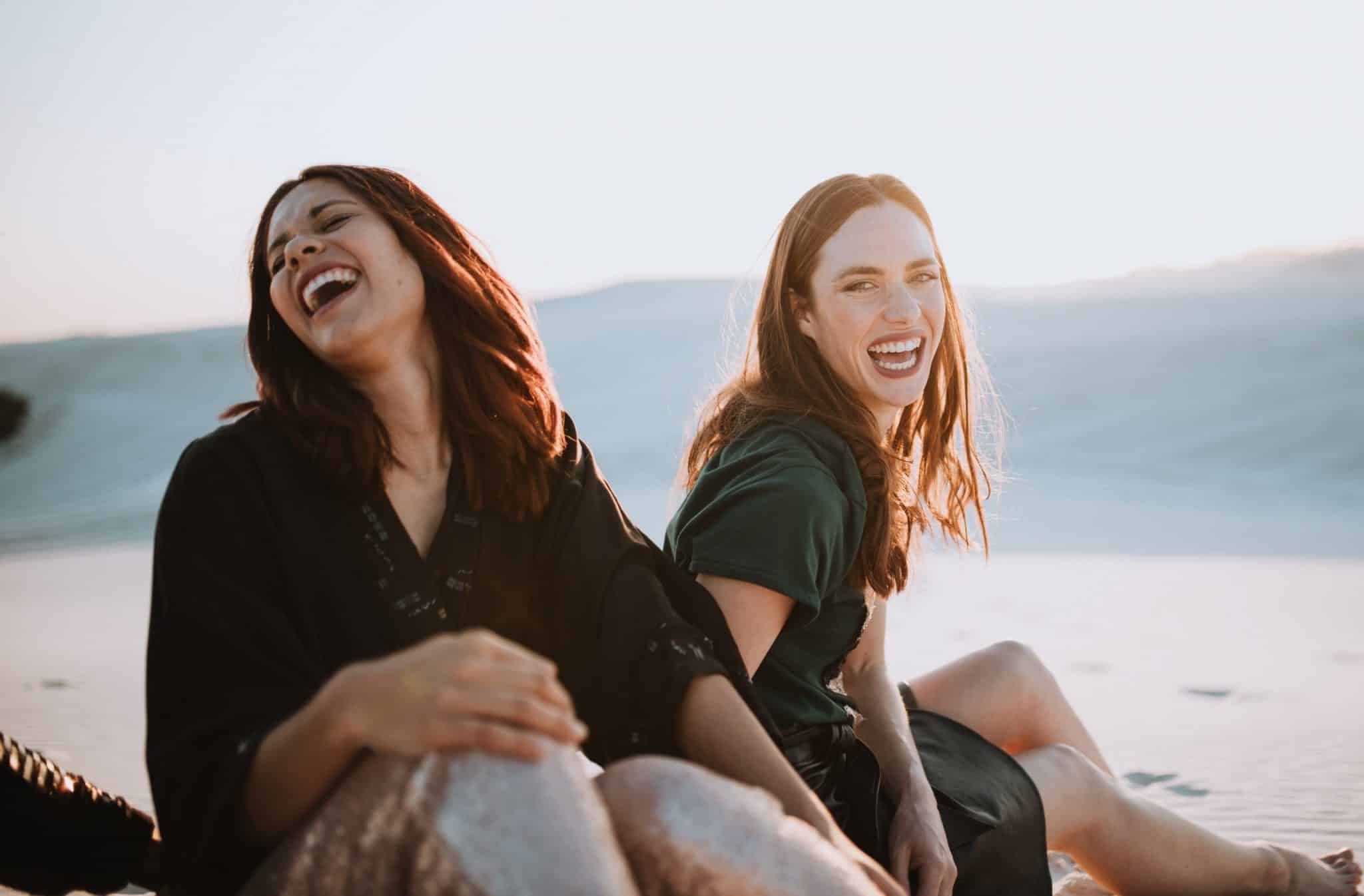 Two Friends Laughing and Enjoying the Sunset