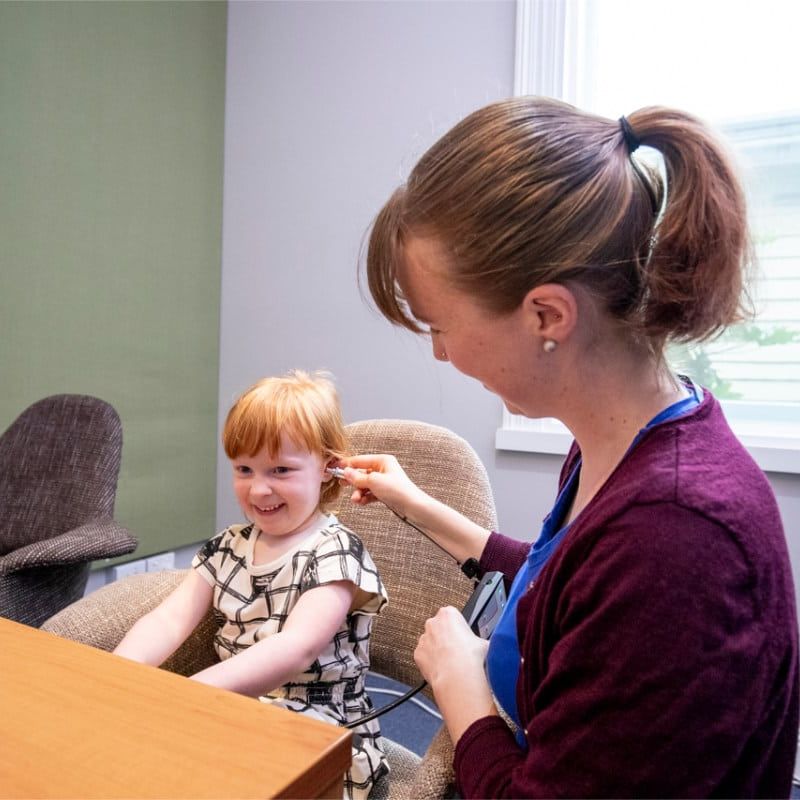 Audiologist performing a hearing test on a child