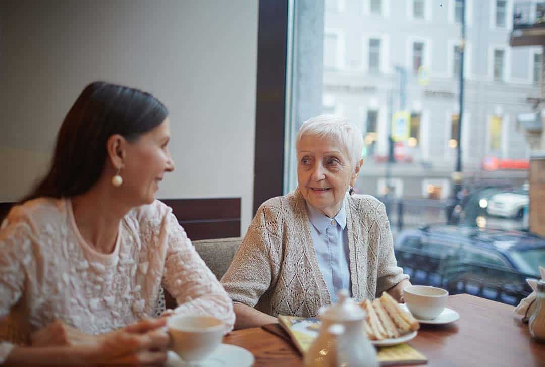 Two Elderly Women Have Tea at a Cafe